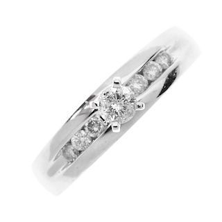 A 9ct gold diamond ring. The brilliant-cut diamond, raised to the tapered band with similarly-cut di