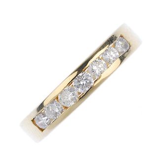 An 18ct gold diamond seven-stone ring. The brilliant-cut diamond line, inset to the plain band. Tota