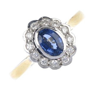 An 18ct gold sapphire and diamond cluster ring. The oval-shape sapphire collet, within a brilliant-c