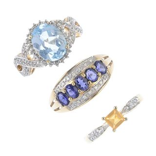 Three 9ct gold gem-set rings. To include a blue topaz and diamond ring, an iolite and diamond band r