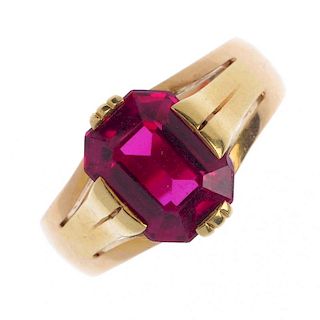 A synthetic ruby single-stone ring. The rectangular-shape synthetic ruby, with trifurcated shoulders