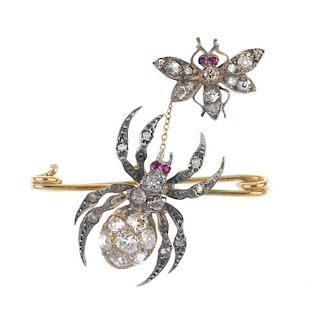 A diamond spider and fly brooch. The vari-cut diamond fly with ruby eye detail, suspended from a tra