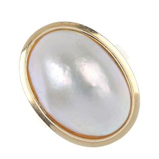 A mabe pearl ring. The oval-shape mabe pearl, within a stepped collet surround, to the plain band. W