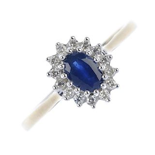 * A 9ct gold sapphire and diamond cluster ring. The oval-shape sapphire, within a brilliant-cut diam
