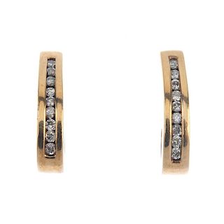 A pair of diamond ear hoops. Each designed as a brilliant-cut diamond line, within a channel-setting