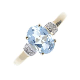 A 9ct gold topaz and diamond dress ring. The oval-shape blue topaz, with single-cut diamond sides, t