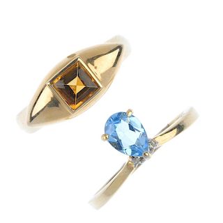 Two gem-set dress rings. To include a blue topaz and diamond accent chevron ring, together with a ci