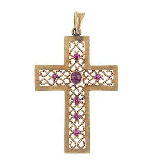 A ruby cross pendant. The circular ruby cabochon and circular-shape ruby cross, atop a scrolling rop