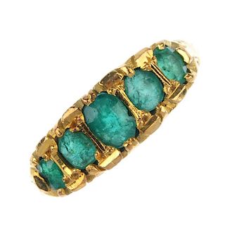 An emerald five-stone ring. The graduated oval-shape emeralds, to the scrolling gallery and plain ba