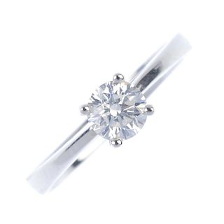An 18ct gold diamond single-stone ring. The brilliant-cut diamond , to the tapered shoulders and pla