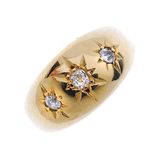 An early 20th century 18ct gold diamond three-stone band ring. The graduated old-cut diamonds, to th