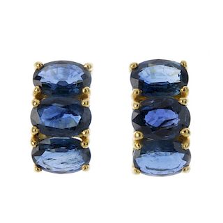 A pair of sapphire ear pendants. Each designed as an oval-shape sapphire three-stone line. Length 1.