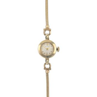 BULOVA - a lady's watch. The circular-shape cream dial with baton markers, to the 9ct gold snake-lin