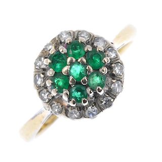 (140001) An emerald and diamond cluster ring. The raised centre of circular-shape emeralds within a