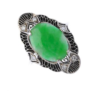 A mid 20th century gold and platinum jade dress ring. The oval jadeite cabochon, within an openwork