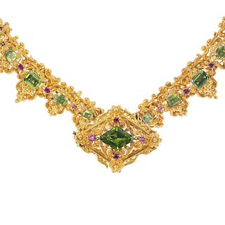An early 20th century gold peridot and ruby necklace and a brooch. The necklace designed as two earl