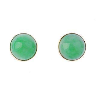 A pair of jade ear studs. Each designed as a circular jadeite cabochon, within a collet setting. Dia