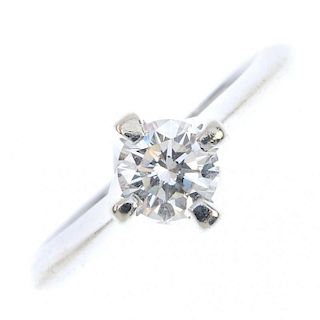 A diamond single-stone ring. The brilliant-cut diamond, to the tapered shoulders and plain band. Dia