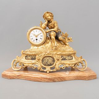 Reloj de chimenea. Alemania, sXX. Elaborado en bronce dorado. Con base de ónix. Con carátula blanca e índices romanos.