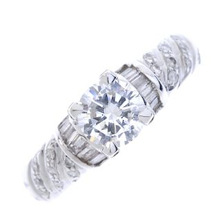 An 18ct gold diamond single-stone ring. The brilliant-cut diamond, with baguette-cut diamond sides a