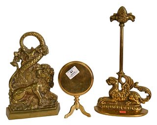Three Piece Brass Group, to include Queen Anne brass trivet with tilt top, lion with serpent door stop, and a winged griffin doorstop, height 14 inche