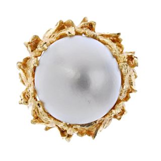 A mabe pearl dress ring. The mabe pearl, measuring 15.4mms, within a textured foliate surround, to t