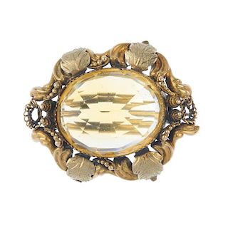 A late 19th century 19ct gold citrine brooch. The oval-shape citrine, within a textured foliate and