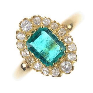 An emerald and diamond cluster ring. The rectangular-shape emerald, within a slightly graduated old-