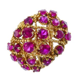 A synthetic ruby bombe ring. The graduated circular-shape synthetic rubies, scattered across a textu