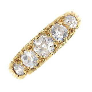An 18ct gold diamond five-stone ring. The graduated old-cut diamond line, to the scrolling gallery a