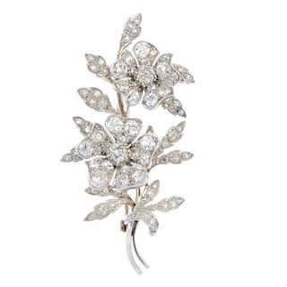 A floral diamond spray brooch. Designed as two old-cut diamond articulated flowers, to the old-cut d