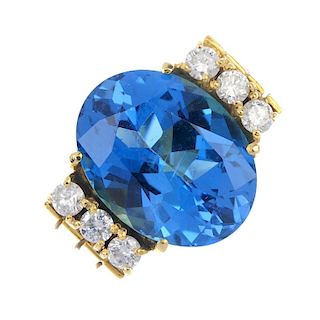A topaz and diamond ring. The oval-shape blue topaz, with brilliant-cut diamond sides, to the split