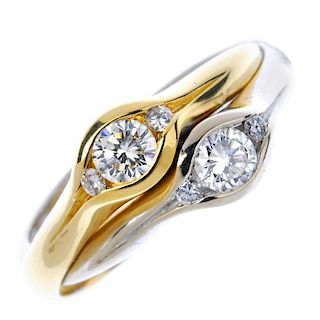 An 18ct gold bi-colour diamond two-stone ring. The brilliant-cut diamonds, with brilliant-cut diamon