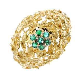 An emerald dress ring.  The circular-shape emerald cluster, raised to the openwork foliate curved pa