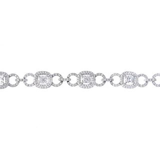 A diamond bracelet. Designed as a series of oval-shape diamonds, each within a pave-set brilliant-cu