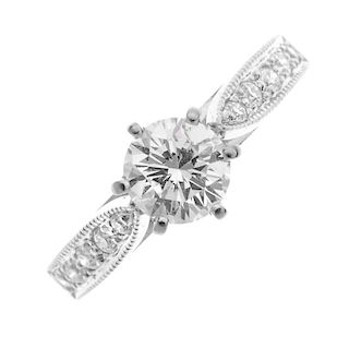 A diamond single-stone ring. The brilliant-cut diamond, to the similarly-cut diamond tapered shoulde