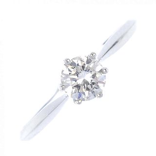 A platinum diamond single-stone ring. The brilliant-cut diamond, to the tapered shoulders and knife-