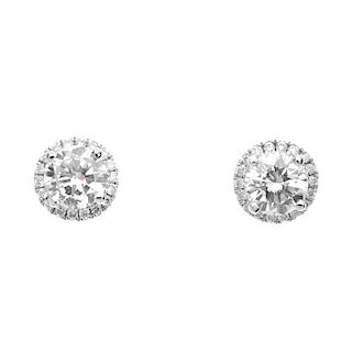 A pair of diamond cluster ear studs. Each designed as a brilliant-cut diamond, with similarly-cut di