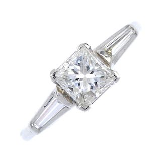 A diamond single-stone ring. The square-shape diamond, to the tapered baguette-cut diamond shoulders