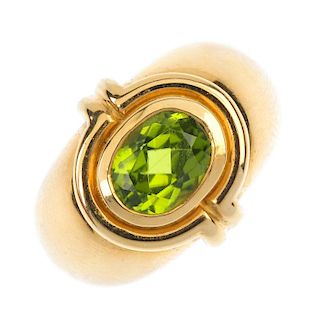 ADLER - a peridot ring. The oval-shape peridot collet, within a curved bar surround, to the tapered