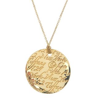 TIFFANY & CO. - a 'Notes' pendant. The undulating disc, with Tiffany & Co. script address, suspended