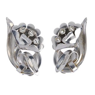 A pair of diamond ear clips. Each designed as flower, with single-cut diamond highlights. Length 3cm
