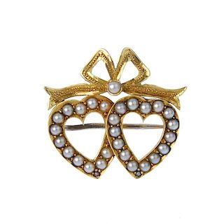 A split pearl brooch. Of openwork design, the split pearl heart duo, with textured bow surmount and