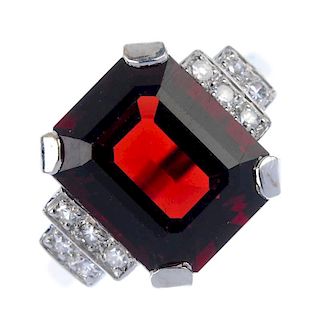 A garnet and diamond dress ring. The rectangular-shape garnet, to the single-cut diamond tiered side