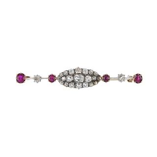 A late 19th century gold diamond and ruby bar brooch. The old-cut diamond marquise-shape panel, with