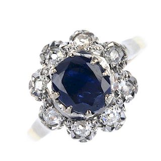 A mid 20th century 18ct gold sapphire and diamond cluster ring. The oval-shape sapphire, within an o