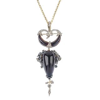 A garnet and diamond pendant. The pear-shape garnet cabochon, with rose-cut diamond foliate sides an