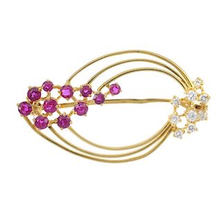 An 18ct gold ruby and diamond brooch. Designed as a series of three tapered hoops, with circular-sha