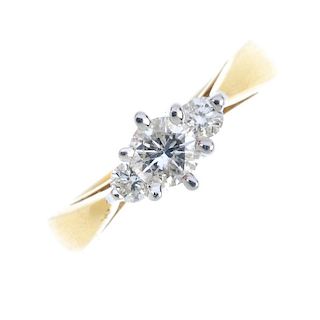 A diamond three-stone ring. The graduated brilliant-cut diamonds, to the tapered shoulders and plain