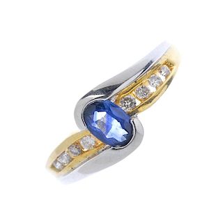 An 18ct gold sapphire diamond crossover ring. Of bi-colour design, the oval-shape sapphire, to the b